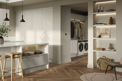 Open plan contemporary Luna Gloss kitchen with a kitchen island, breakfast bar, tall cabinetry, matching open shelves in living room with natural material decorations and utility room with integrated washing machine and tumble dryer, Amtico smouldering oak parquet flooring.