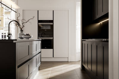 Handleless frame doors Integra Wardley Sumi black kitchen and kitchen island, Integra Soho Limestone tall cabinets with integrated ovens, natural shade ceramic vase holding foliage branches.