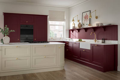 Traditional Shaker-style tactile woodgrain Ludlow kitchen in bold shade Morello with matching wall panel and shelves, brass accents such as knobs and brass tap, a white ceramic sink, Ludlow parchment kitchen island and dusty oak vinyl flooring.