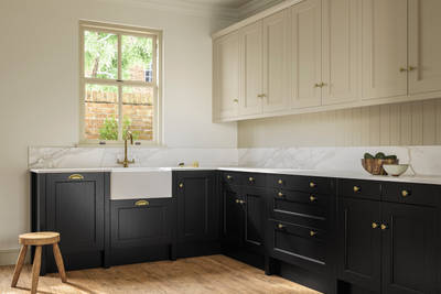 Traditional Shaker-style tactile woodgrain Ludlow Sumi Black kitchen with Ludlow French Clay wall cabinets with matching wall panel, brass knobs and brass tap, white ceramic sink, white and grey marbled worktop and splashback, oak stripwood vinyl flooring.
