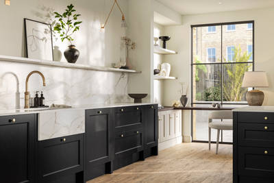 Traditional Shaker-style tactile woodgrain Ludlow Sumi Black kitchen with kitchen island, light and airy with brass accessories, marbled white and grey worktop, home office area by full height windows and Amtico oak stripwood vinyl flooring.