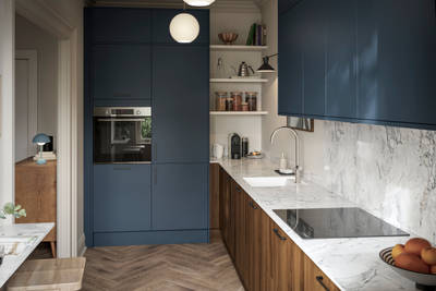 Contemporary Ascoli Mineral Blue tall cabinets and wall cabinets over Portobello Umbra kitchen cabinets with marbled compact laminate worktop, black handles and Amtico smouldered oak herringbone flooring.