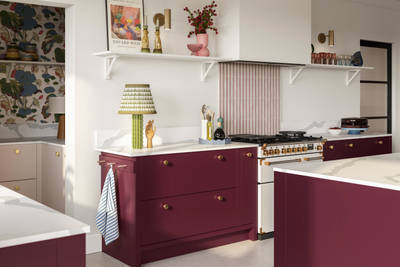 Modern slab front Soho Morello and Shell kitchen with kitchen island, Bianco calacatta worktop and upstand, brass knobs and open wall shelves holding eclectic decorations and glasses.