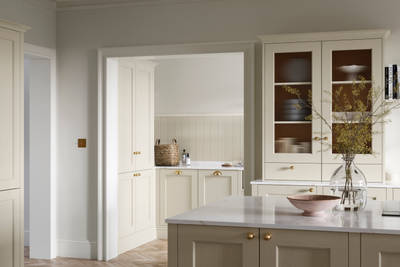 Open plan living room and Traditional Shaker-style kitchen Ludlow Parchment and view of utility room with white ceramic trough door frame, Goodrich Natural Oak herringbone engineered flooring, brass handles, brass knobs and bras tap.
