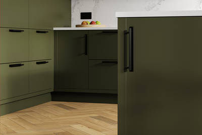 Modern slab front Soho Tailored Green kitchen with black handles, white marbled worktop and matching backsplash, wooden herringbone parquet flooring.