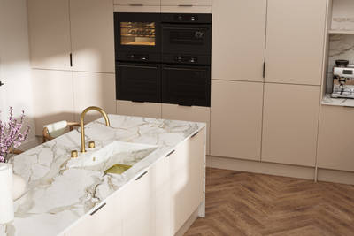 Fluted front kitchen Reed from Magnet in light warm neutral shade Shell, with a marbled splashback and worktop, brass tap in kitchen island sink