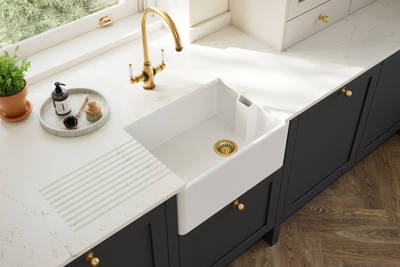 Overhead view of veramic belfast sink and brass tap in Contemporary Shaker kitchen Ambleside from Magnet in deep blue shade Lake with beige tall cabinets