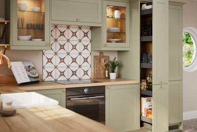 Opened pull-out larder in contemporary Shaker kitchen Ambleside from Magnet in sage green shade Meadow with belfast sink, aged taps and wooden effect worktop.