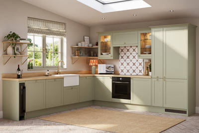 Contemporary Shaker kitchen Ambleside from Magnet in sage green shade Meadow with belfast sink, aged taps and wooden effect worktop.
