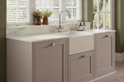 Shaker style painted wood grain cabinets Bewdley in the shade Cornish Clay with a marbled worktop and matching upstand, striped belfast sink with ceramic handle stainless steel tap.