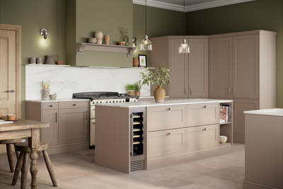Shaker style painted wood grain Bewdley kitchen in neutral shade Cornish Clay, tall cabinets and kitchen island with marbled worktop and matching backsplash, wine cooler in the kitchen island and gas range cooker.