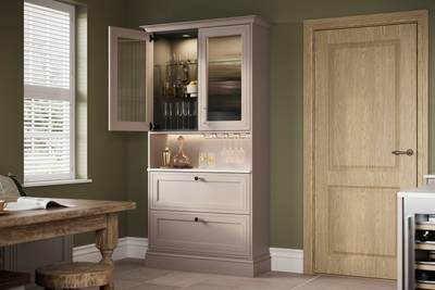 View from dining area of Shaker style painted wood grain dresser cabinets Bewdley Cornish Clay, ribbed glass vitrine with built-in lighting.