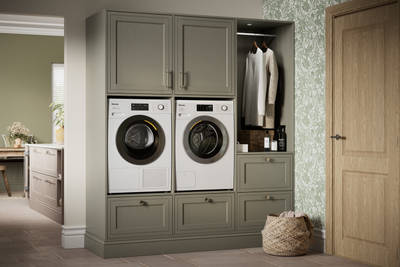 Shaker style painted wood grain cabinets Bewdley cabinetry laundry room, tall cabinets with built-in washing machine and tumble dryer in green shade Balmoral.