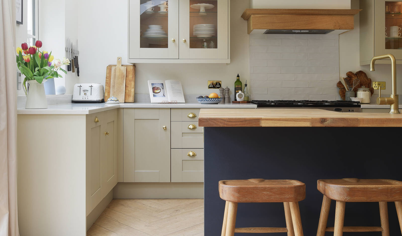 View of bar stools by the kitchen island in the Shaker-style country cottage kitchen from Magnet