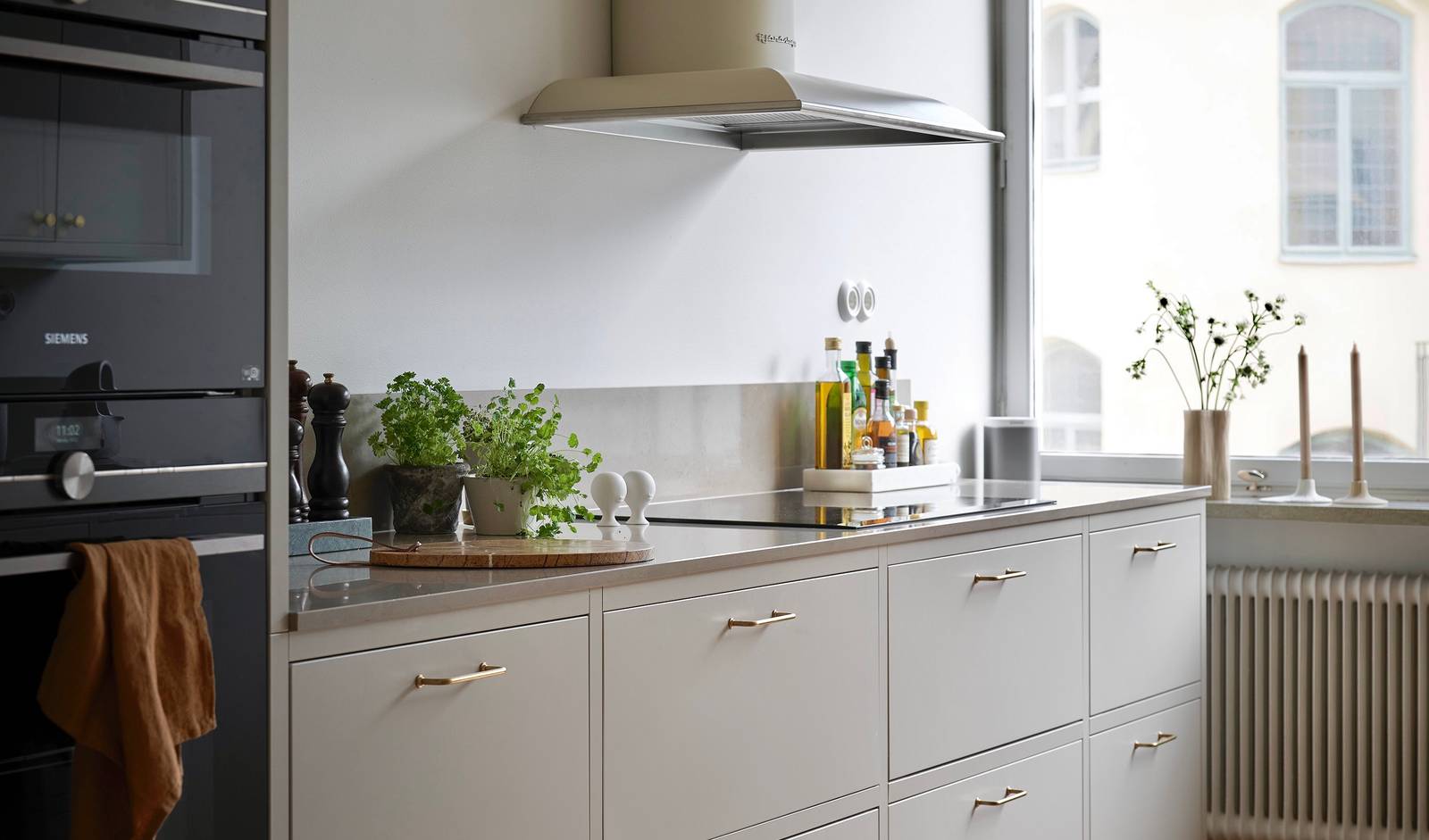 Forrammekøkken Athena Fusion i lys grå farve Sky fra INVITA med grå stein bordplade, rustfrit stål håndtag