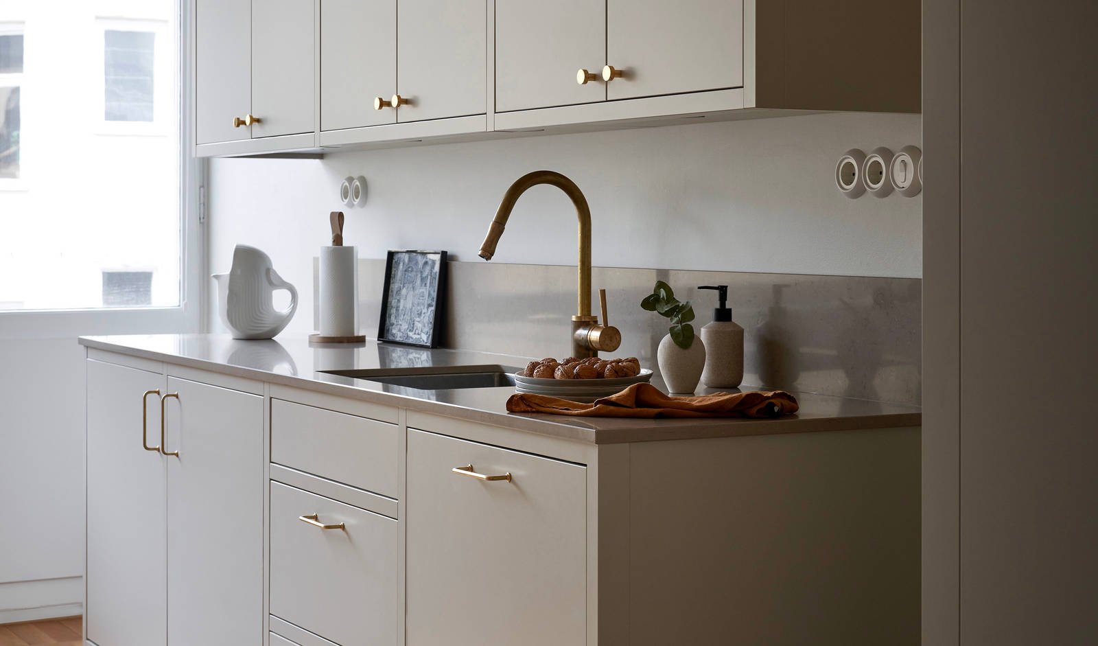 Forrammekøkken Athena Fusion i lys grå farve Sky fra INVITA med grå stein bordplade, messing håndtag