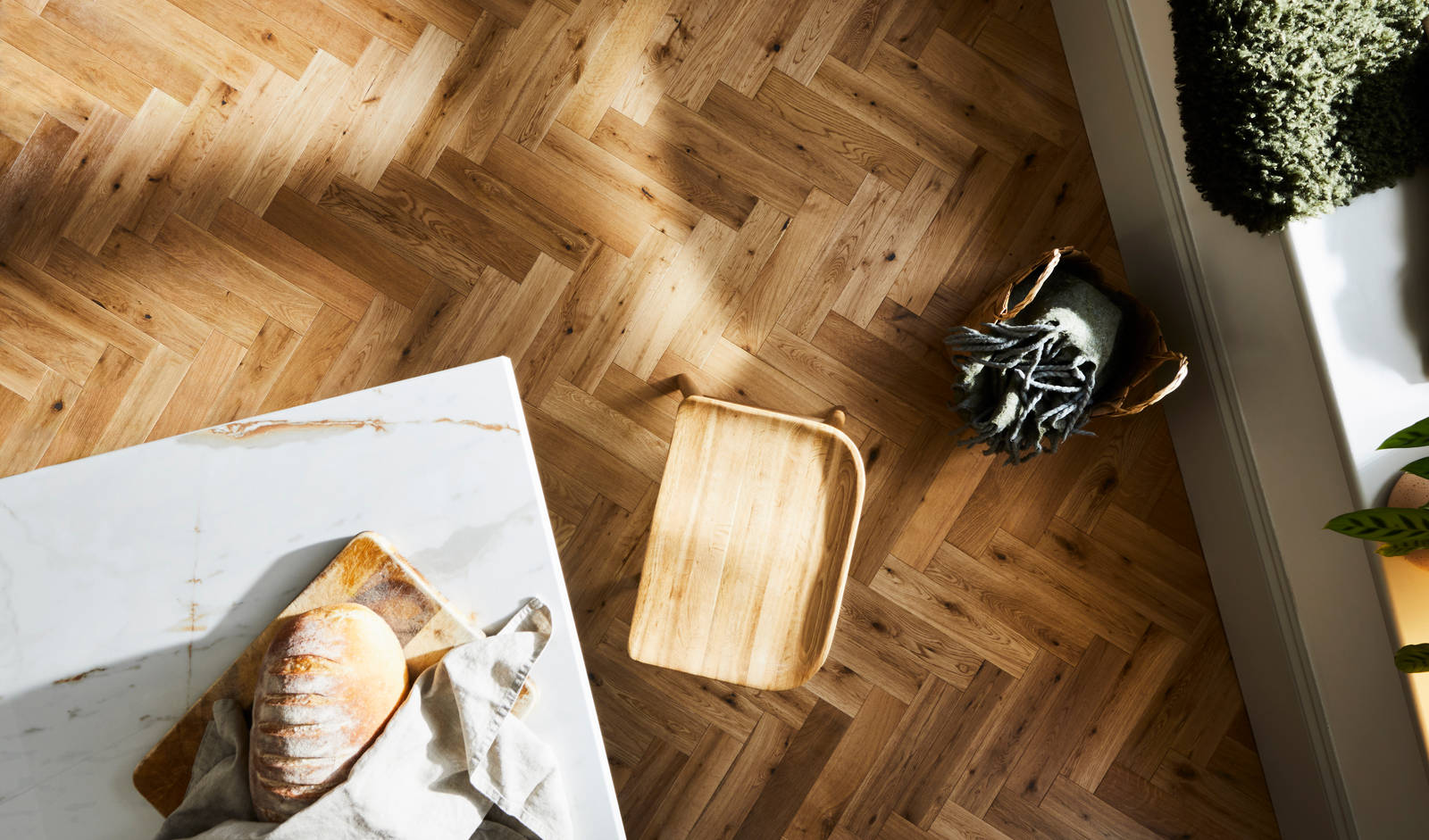 Overhead view of marbled worktop kitchen island corner and the wood floor