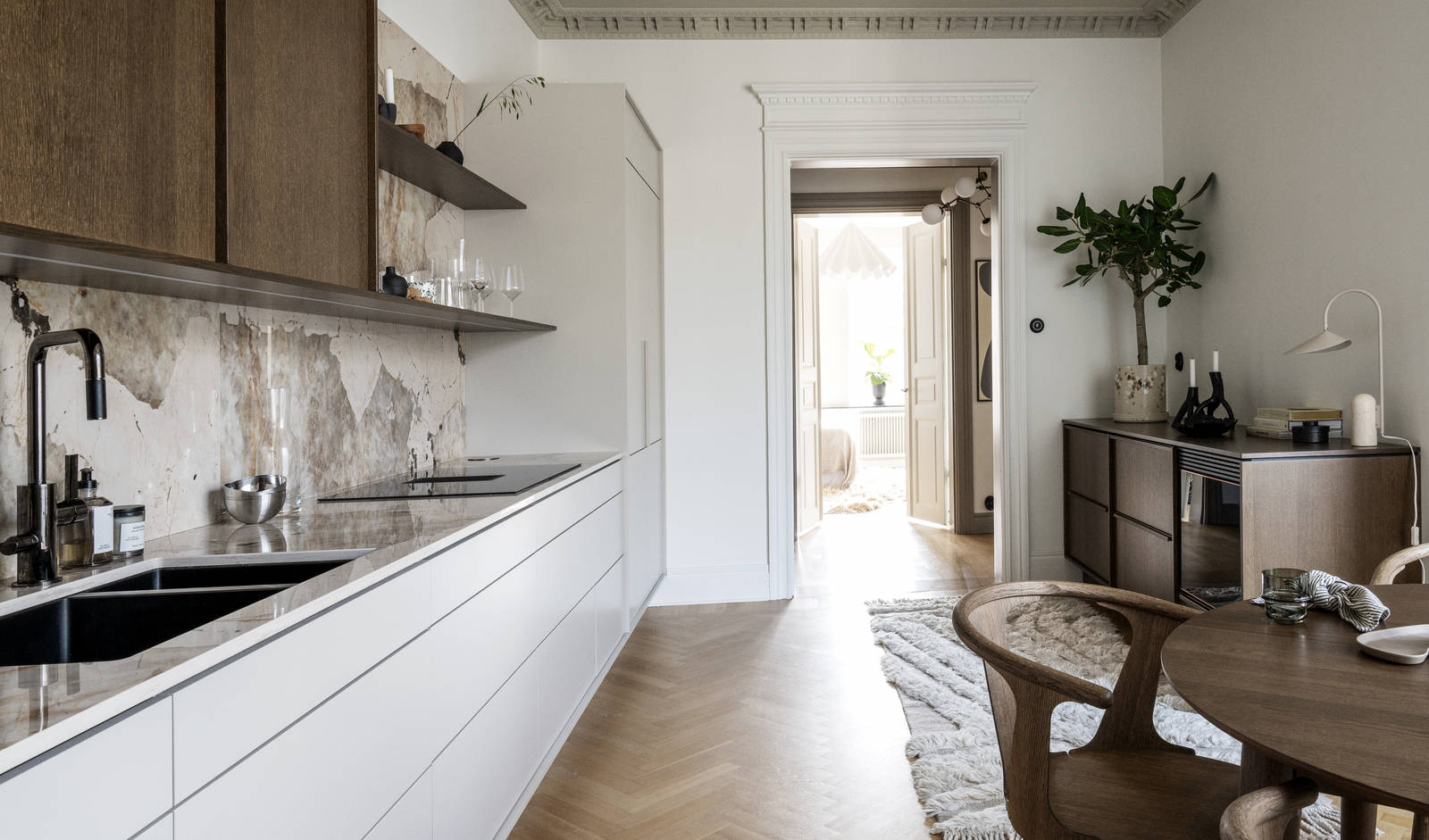 Kjøkken med kombinasjon av kjøkkenbenk i beige Line Korn med overskap i Favn finert eikedør i brunbeis fra Sigdal, benkeplate og sprutbak som matcher, og åpne vegghyller i brunbeiset eikefiner.