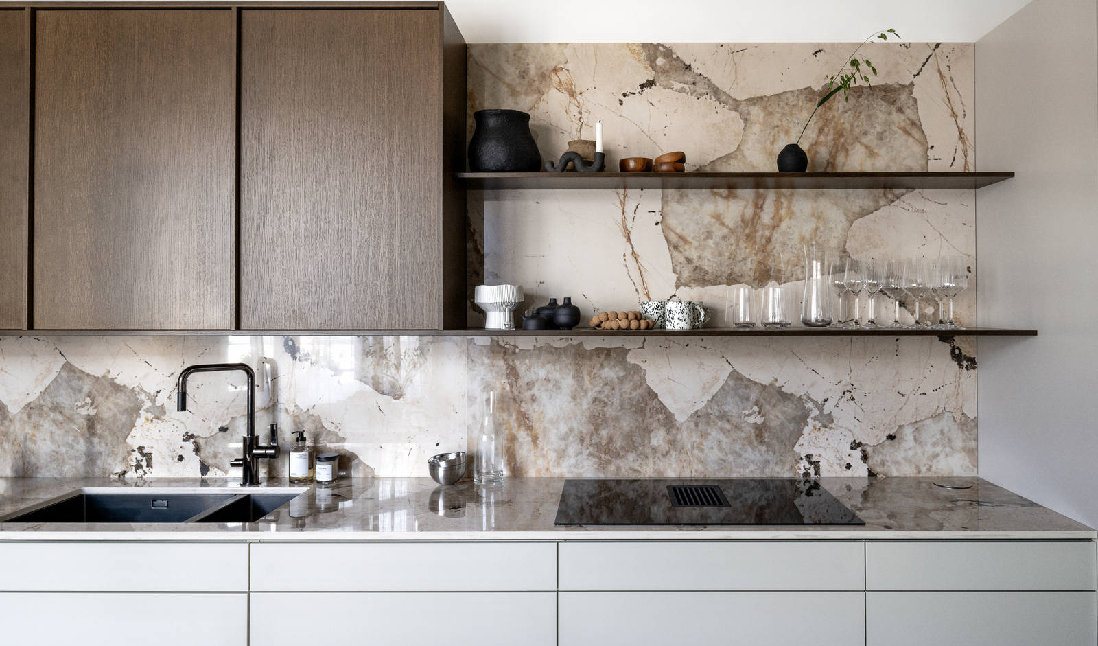 Kjøkken med kombinasjon av kjøkkenbenk i beige Line Korn med overskap i Favn finert eikedør i brunbeis fra Sigdal, benkeplate og sprutbak som matcher, og åpne vegghyller i brunbeiset eikefiner.