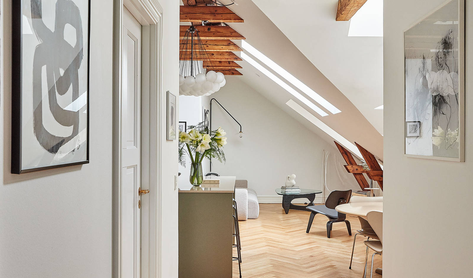 Athena-køkkenet fra INVITA med køkkenøy i den grønne farve Oliven, og de mørke træbjælker.