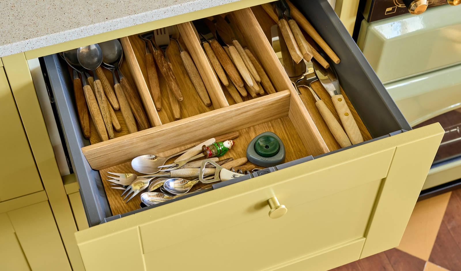 Åpnet kjøkkenskuff med bestikkinlegg i tre