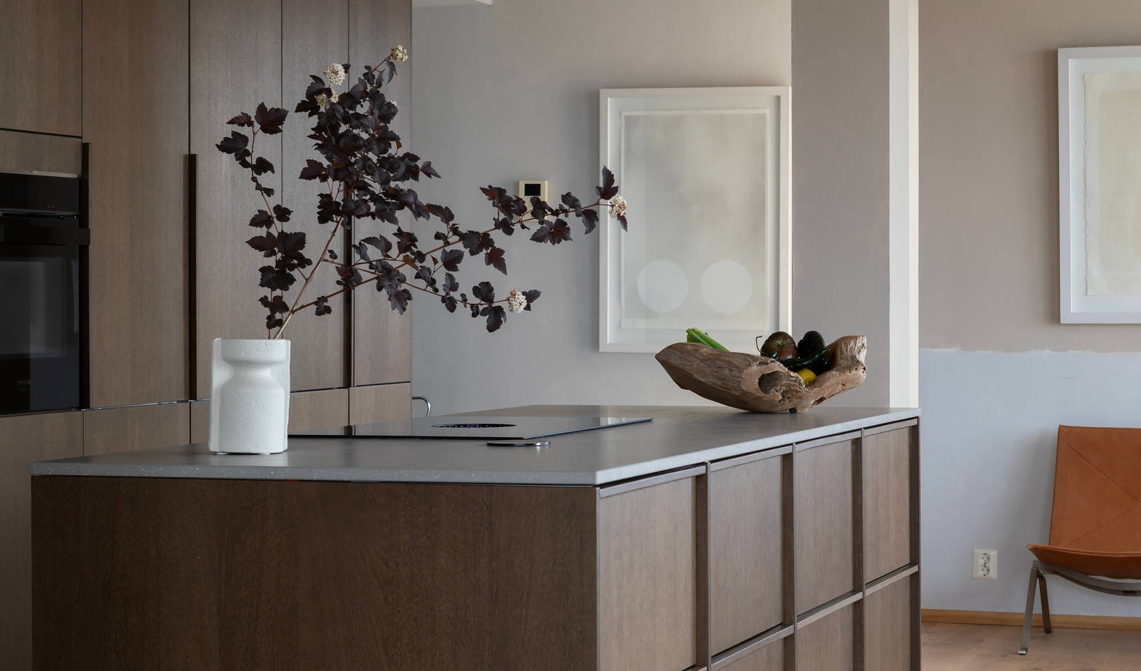 Kjøkkenet hjemme hos Knut og Kjartan, Favn nøtt kjøkkenøy och høyskap med Line Korn fra Sigdal og grå benkeplate.