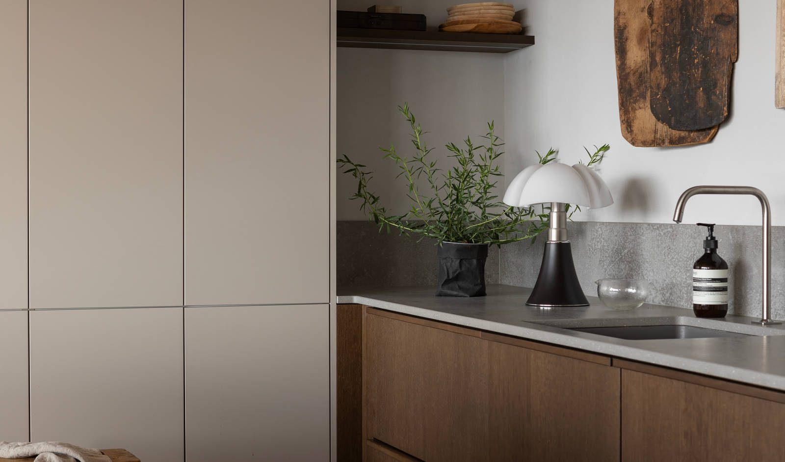 Køkken i brun egetræsfiner køkkenet Forever oak med matchende tre håndtag fra INVITA og beige højskabe Athena Sand