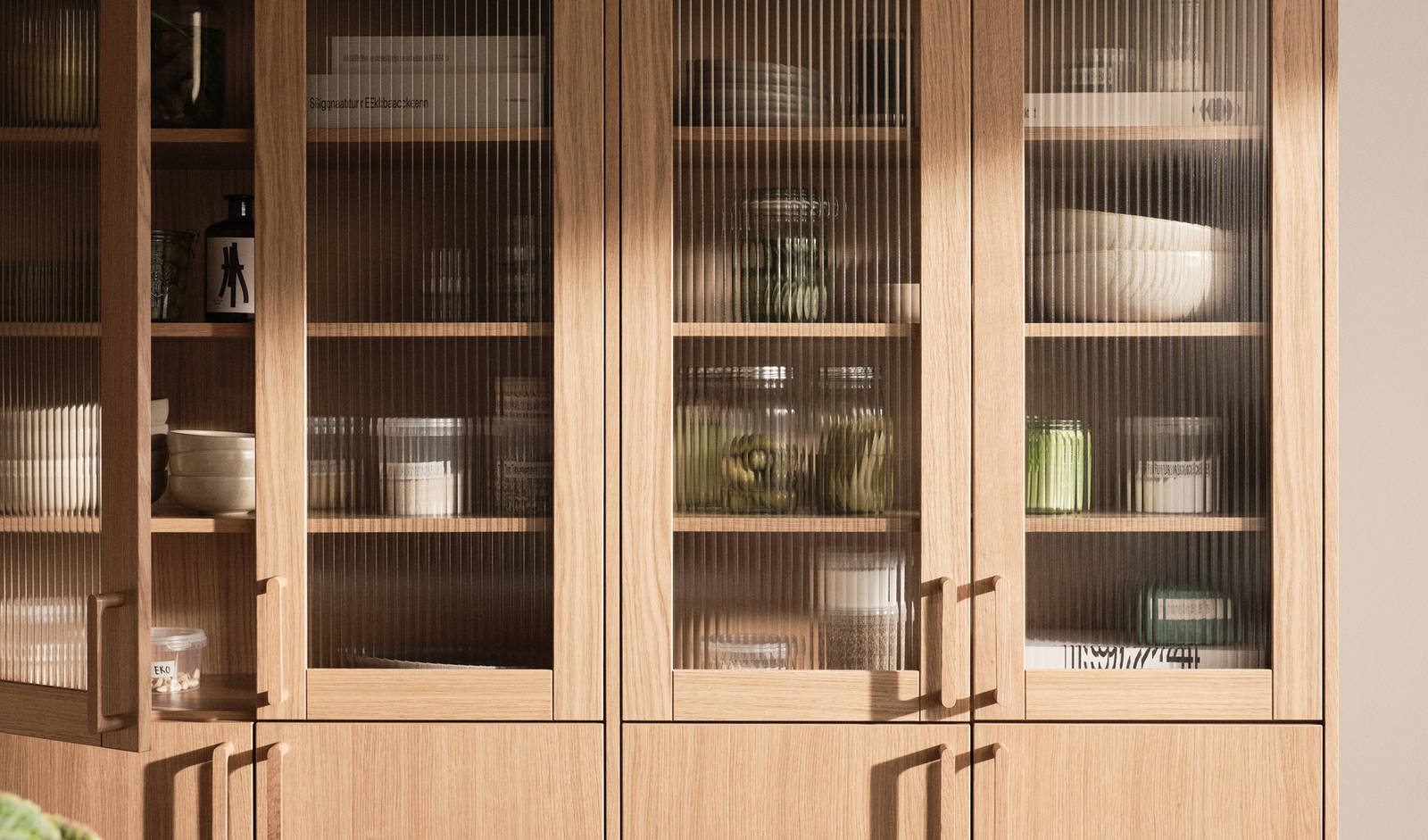 Kjøkken i eikefinér Favn, vitrinedør square med rillede glass og eik håndtak.