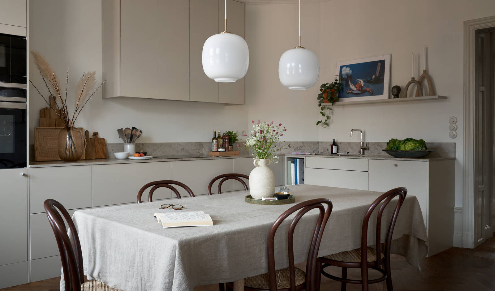 Ved å flytte kjøkkenet til leilighetens tidligere stue skapte Anders og Martina et hjem som passer familiens hverdag bedre. I dag er kjøkkenet et naturlig samlingspunkt – et sted for matlaging, gode samtaler og lange kvelder i den varme kveldssolen. La deg inspirere av det beige kjøkkenet, hvor stilrent design møter personlige detaljer.