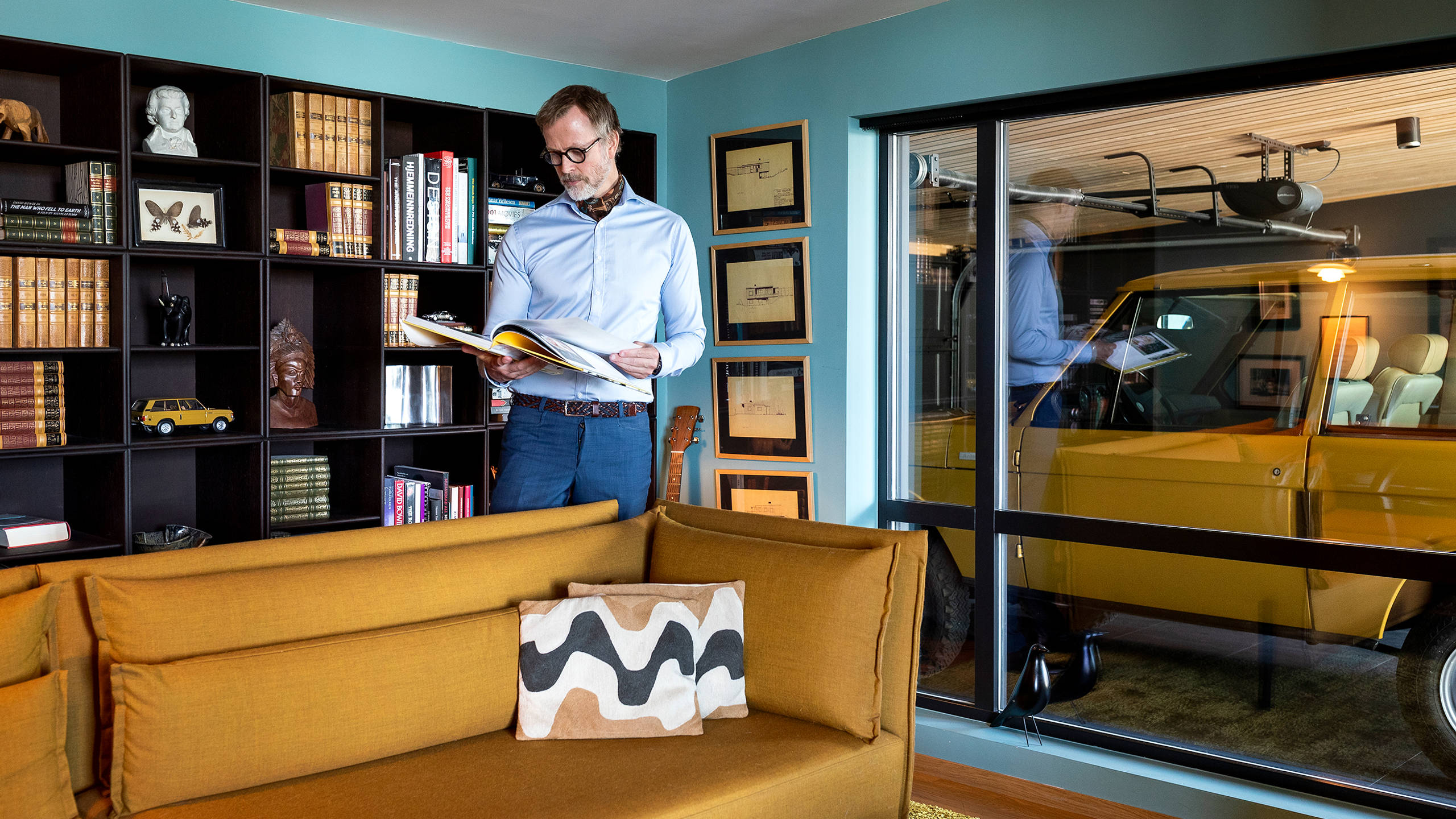 Fra biblioteket har Haakon frit udsyn til garagen, hvor det store vindue indrammer bilen, nærmest som et kunstværk