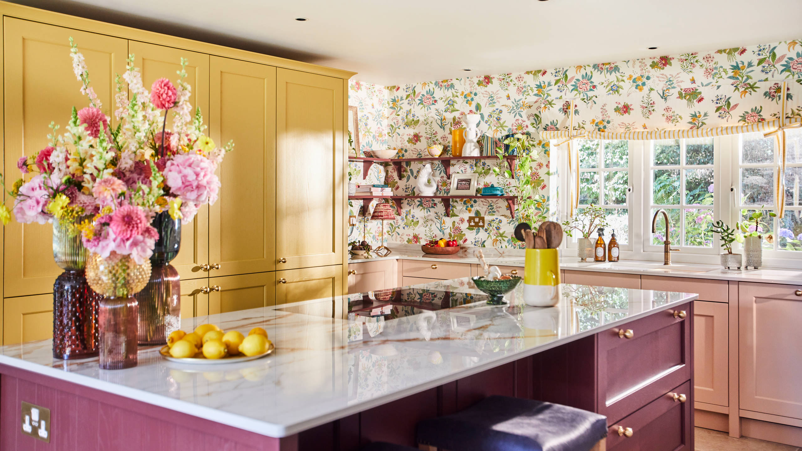 View of Burlington Red kitchen island in Sophie Robinson's vibrant Ludlow kitchen from Magnet with cabinetry in colours Harvest and Chalk Blush.