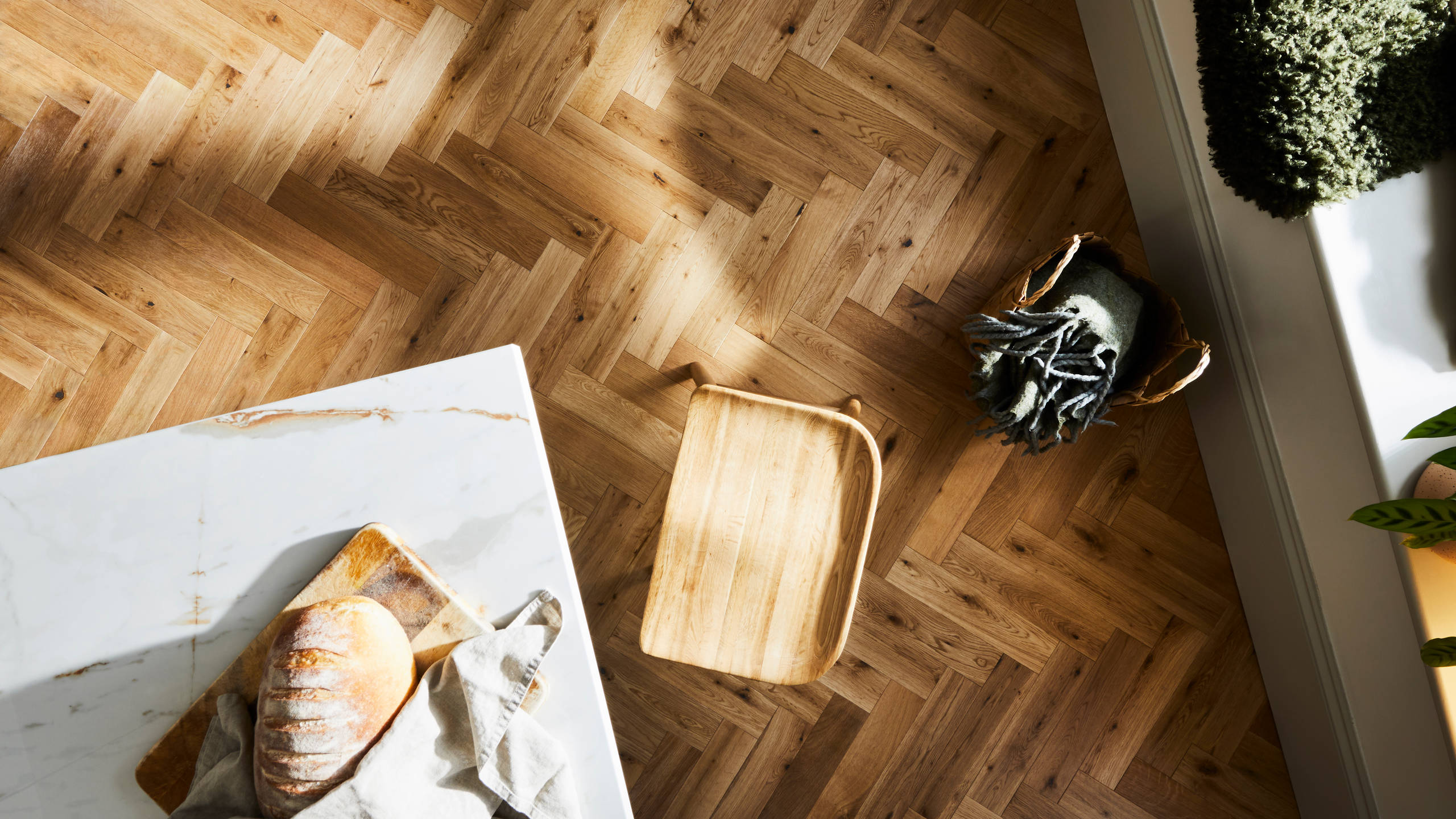 Overhead view of marbled worktop kitchen island corner and the wood floor