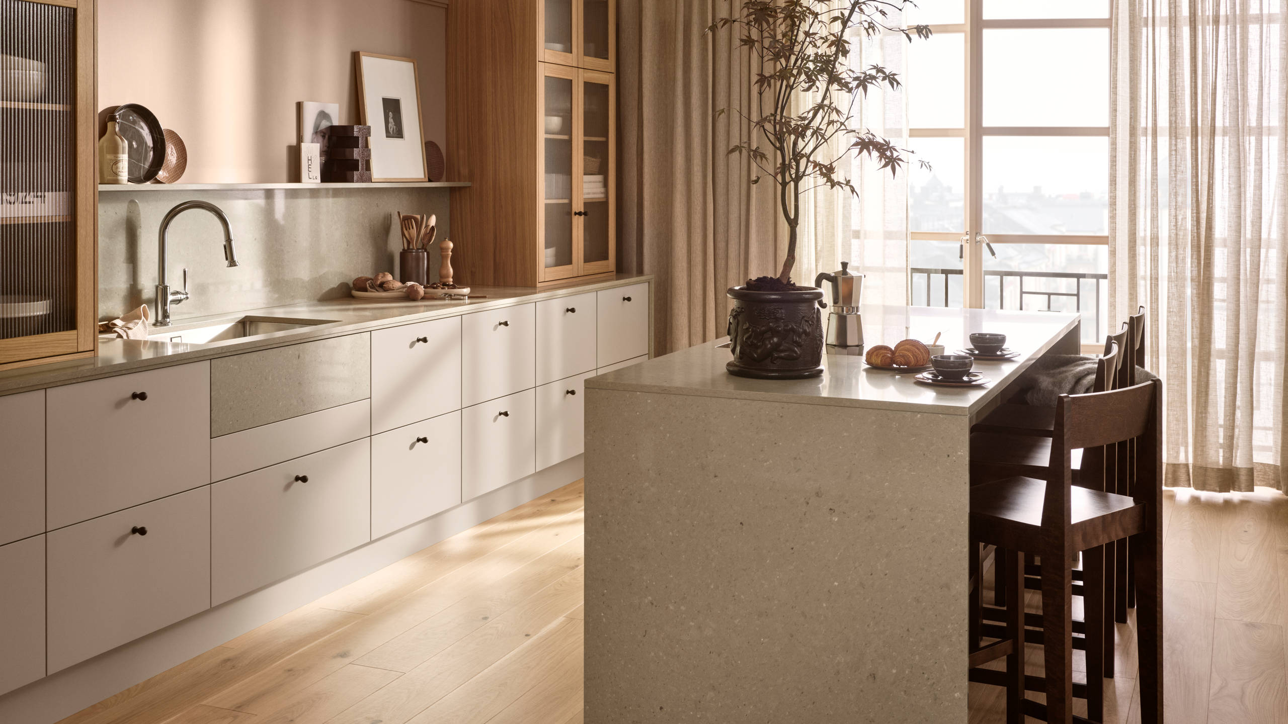 Köksö i beige köket Arkitekt plus gryning från Marbodal, med bardisk i köksön, belfast diskho, vitrinskåp med träram i ek och räfflat glas ovanpå köksbänken
