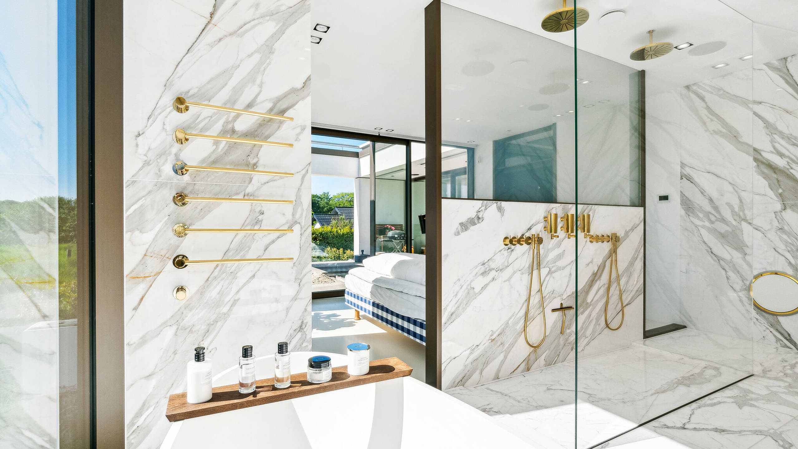 Messingarmaturerne fra vola matcher de honninggyldne årer i den eksklusive Calacatta Gold marmor