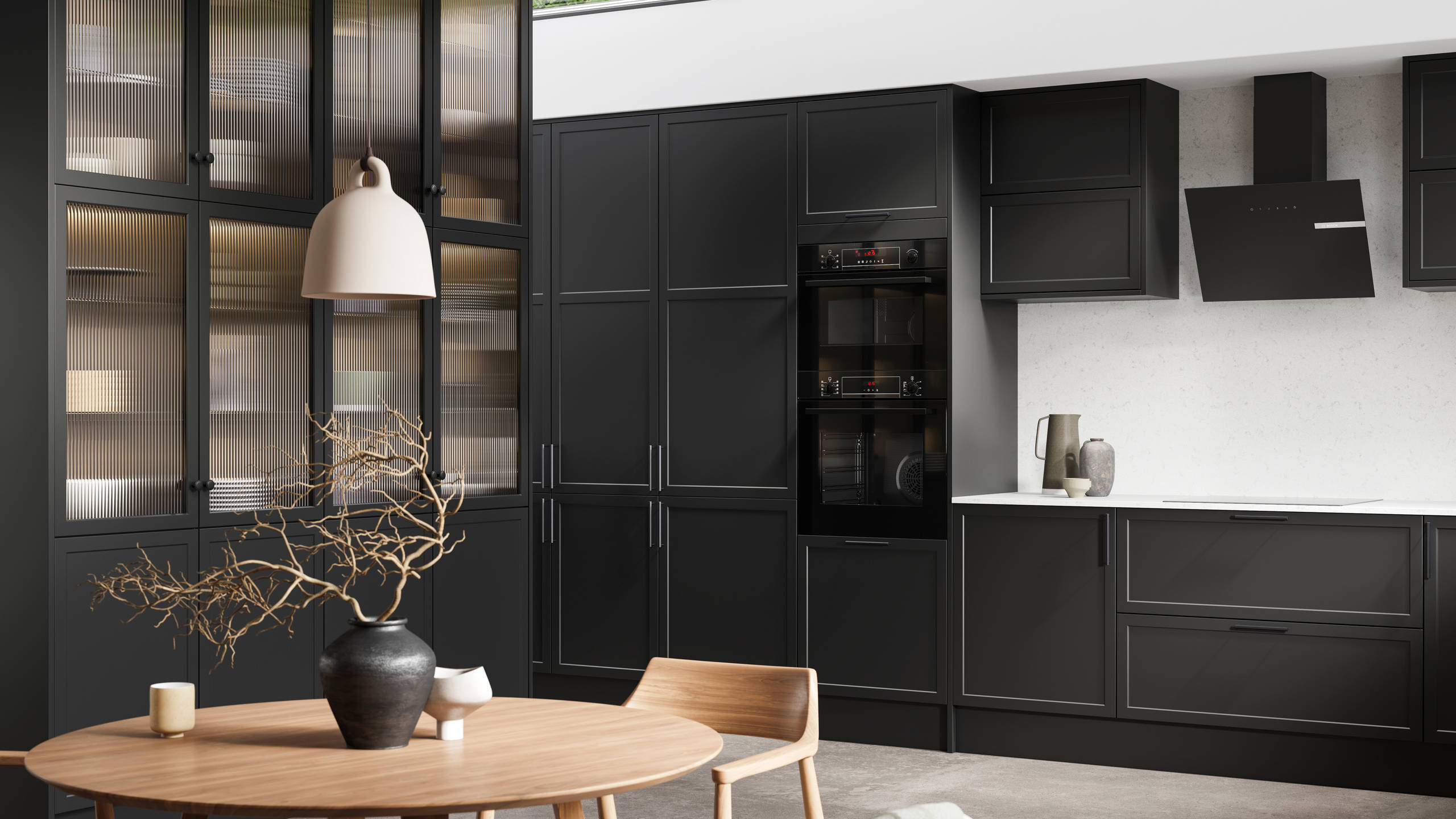 View of modern shaker kitchen Brunswick Sumi Black, with screen extractor over induction hob, tall fluted glass doorsvitrine cabinets, black frame skylights with wood dining table and chairs in foreground.