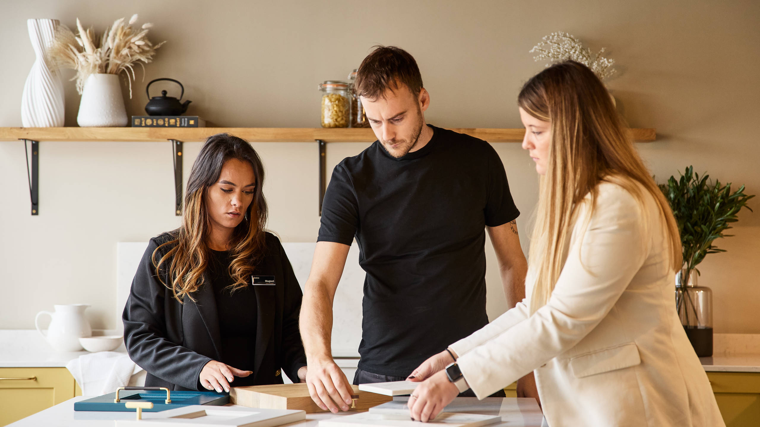 Magnet kitchen designer and Trade customers discussing samples in a display kitchen at Magnet Store