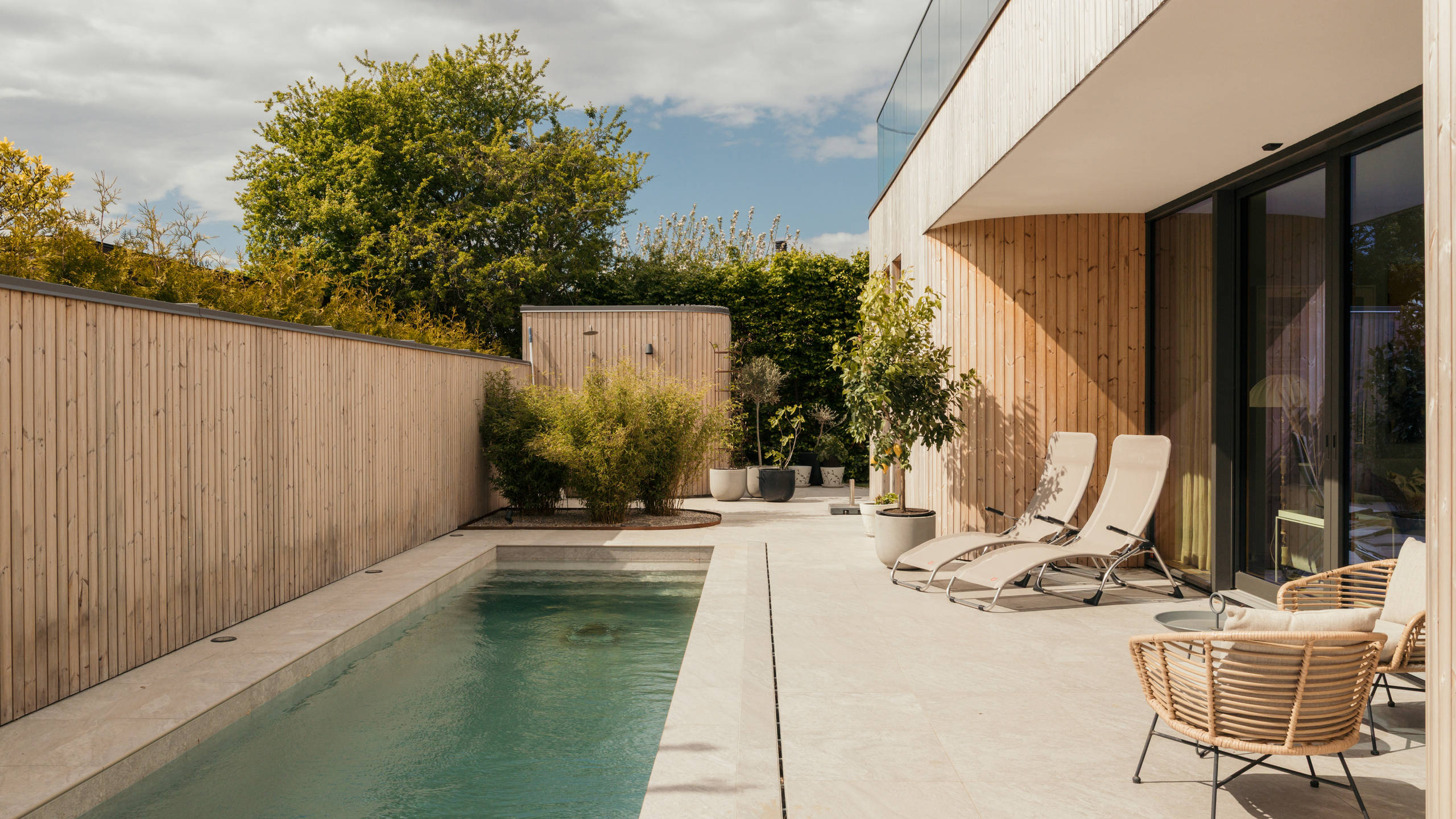 From the kitchen and dining room, there is direct access to the courtyard with a pool, which serves as an additional living space and a beautiful summer oasis for the family.