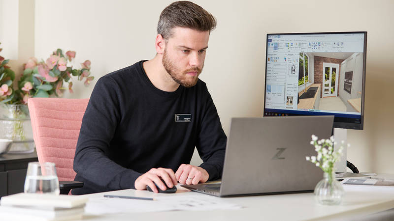Magnet colleague at a desk at a Magnet store designing a kitchen on a computer