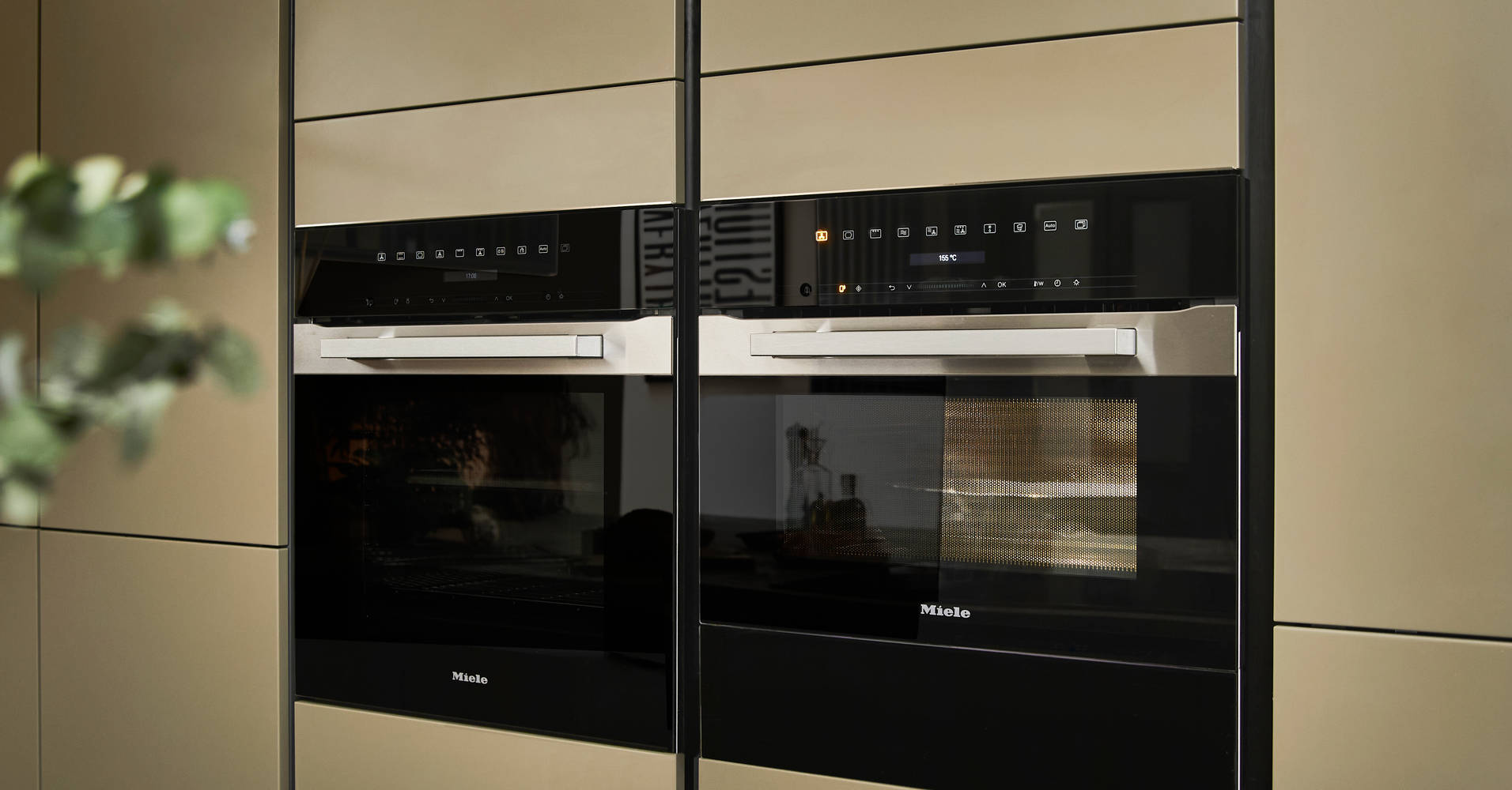 Built-in Ovens in modern slab front Balmoral Soho cabinetry from Magnet, Dekton in Ceppo worktop of kitchen island in foreground.