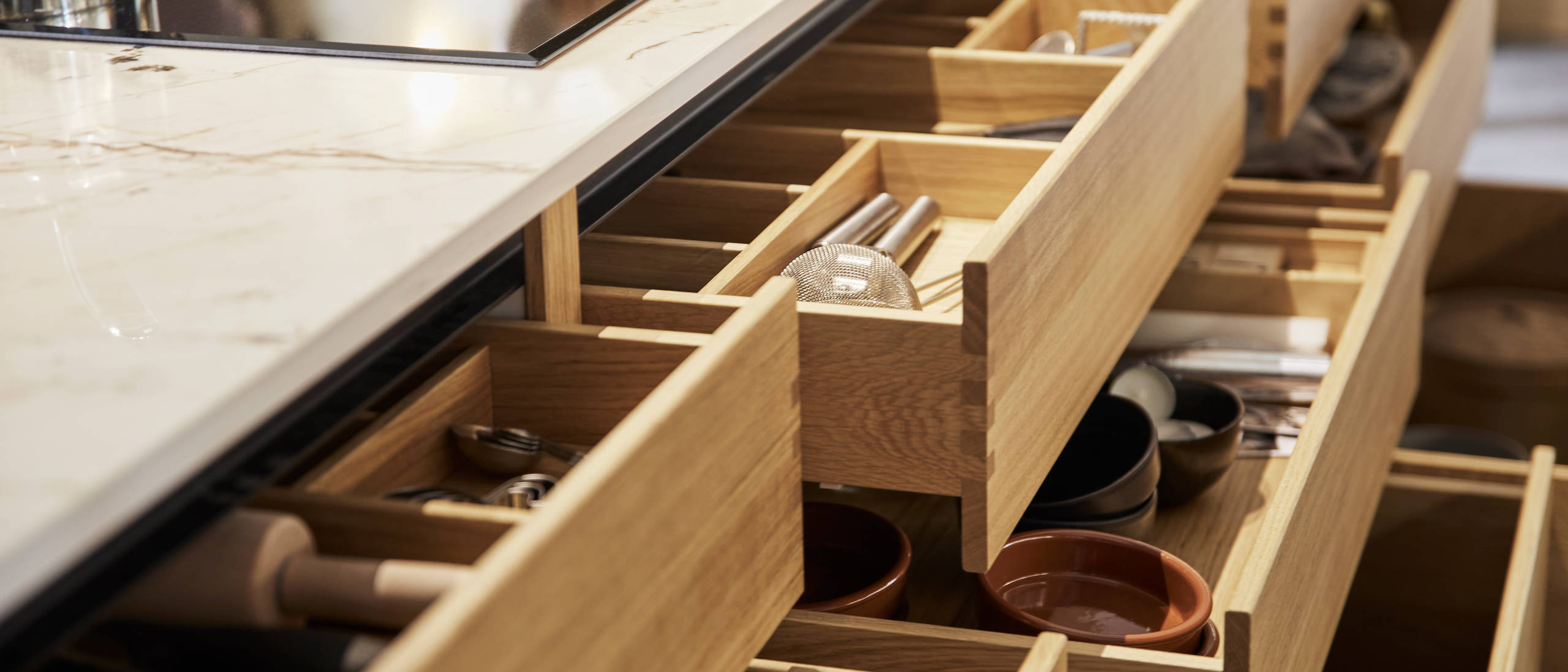 Full view of oak inserts in opened oak drawers in the Nordic Craft kitchen island.