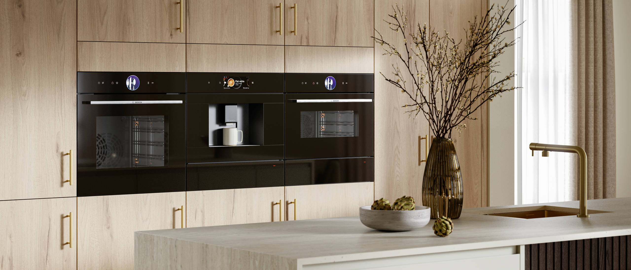 Modern Portobello kitchen cabinets in Bosco are finished with brass bar handles.