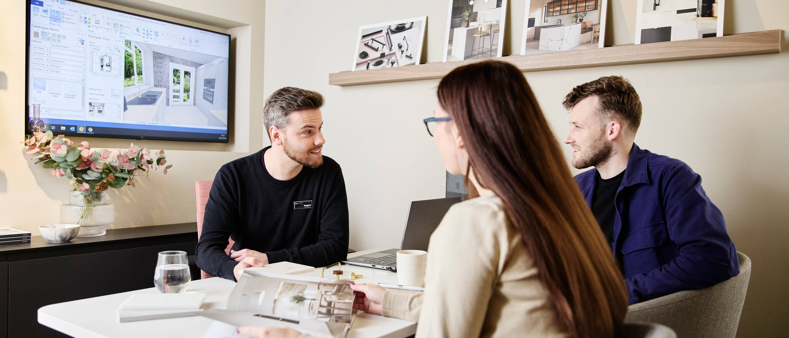 Magnet kitchen designer consulting customers in a Magnet store, woman browsing a brochure.
