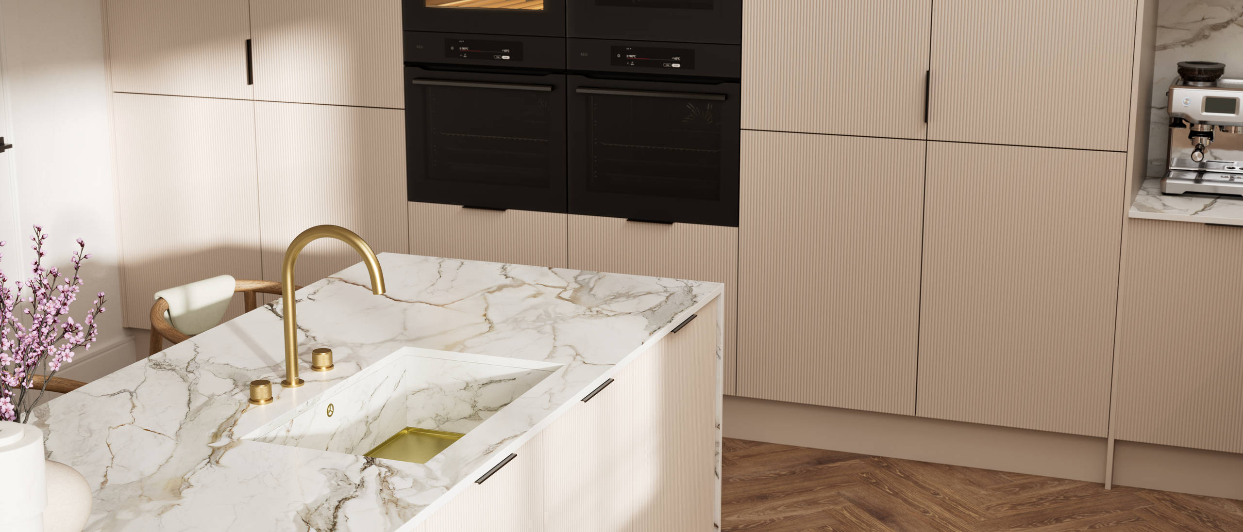 Fluted front kitchen Reed from Magnet in light warm neutral shade Shell, with a marbled splashback and worktop, brass tap in kitchen island sink