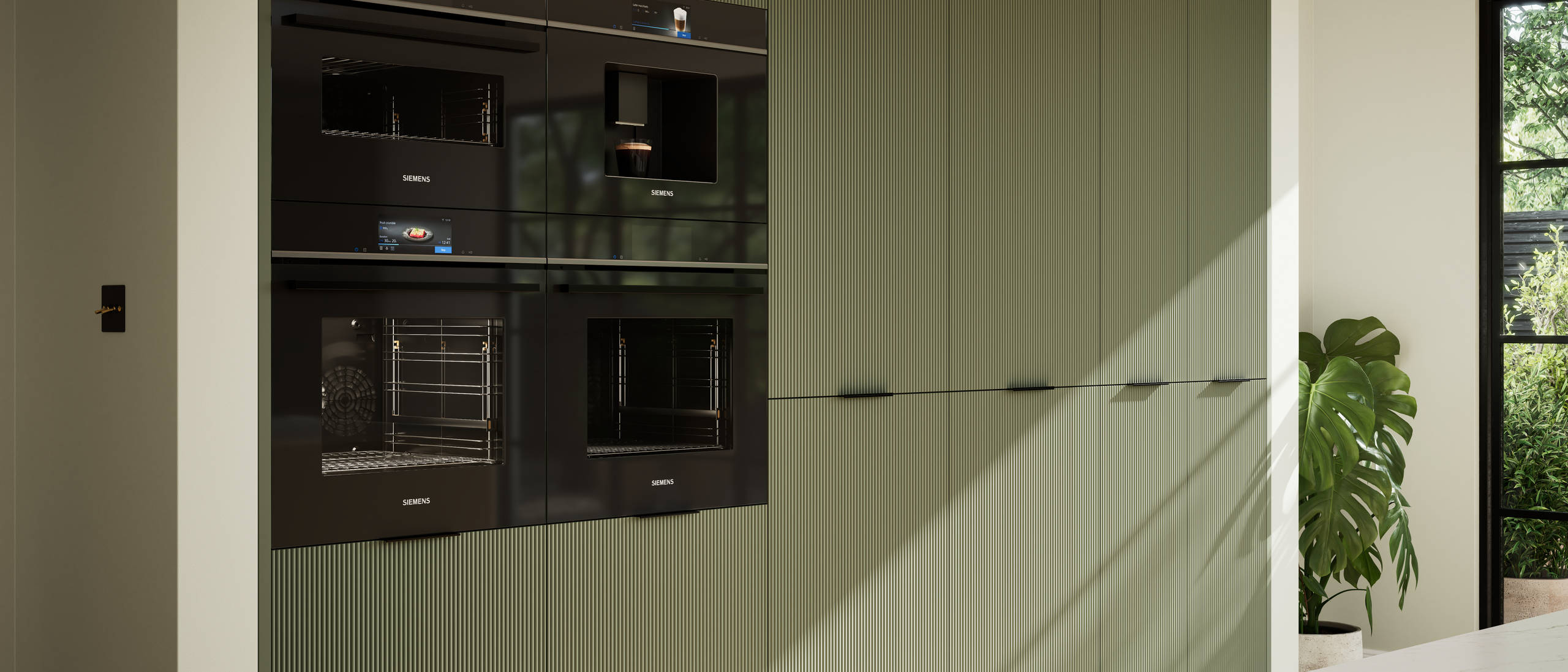 Green fluted kitchen fronts on tall cabinets with built-in appliances and black handles.