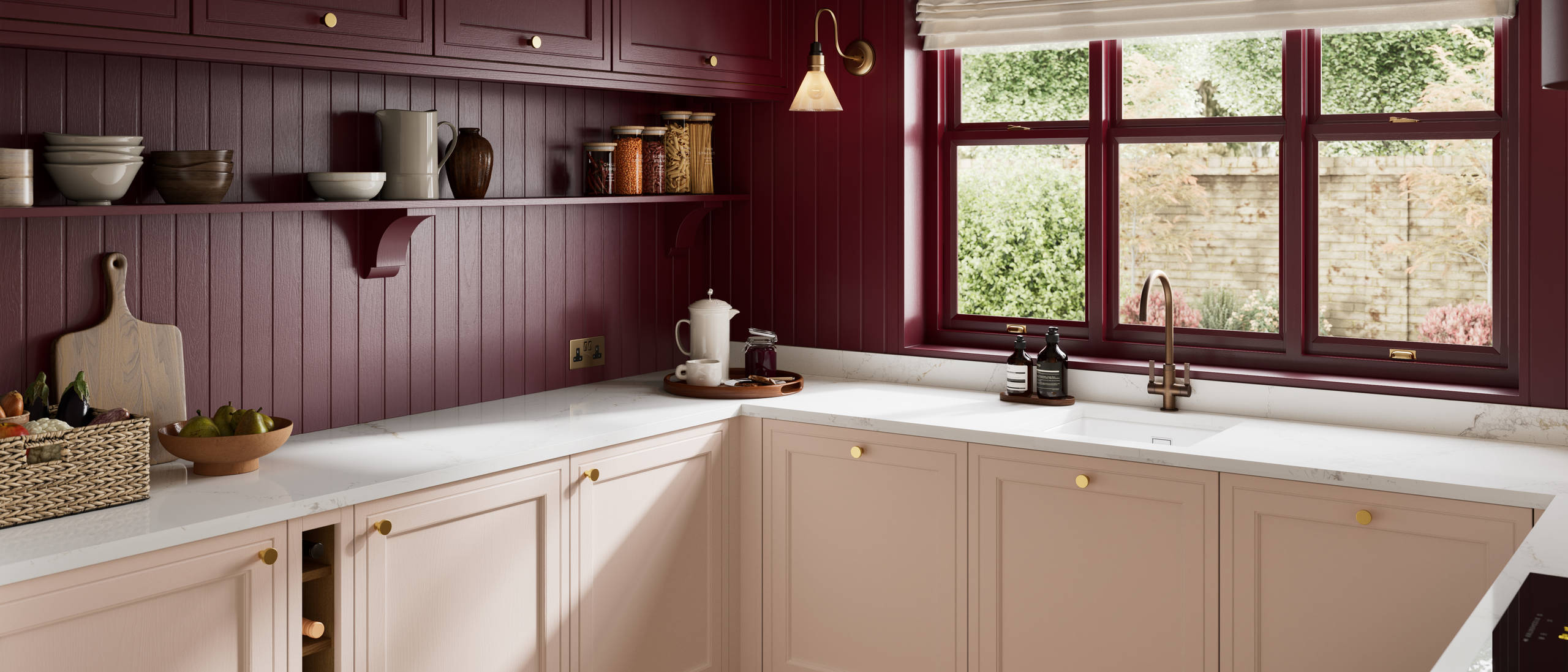 Painted wood grain Shaker style Bewdley kitchen with cabinets in light pink shade Chalk Blush, marbled worktop, brass knobs, red Morello wall-mounted cabinets with matching shelves and wall panel, built- in wine storage.