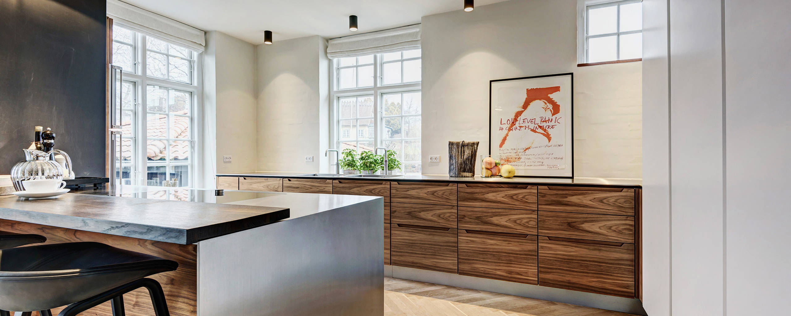 De varma valnötsfronterna kontrasteras av det svala stålet på bordsskivan