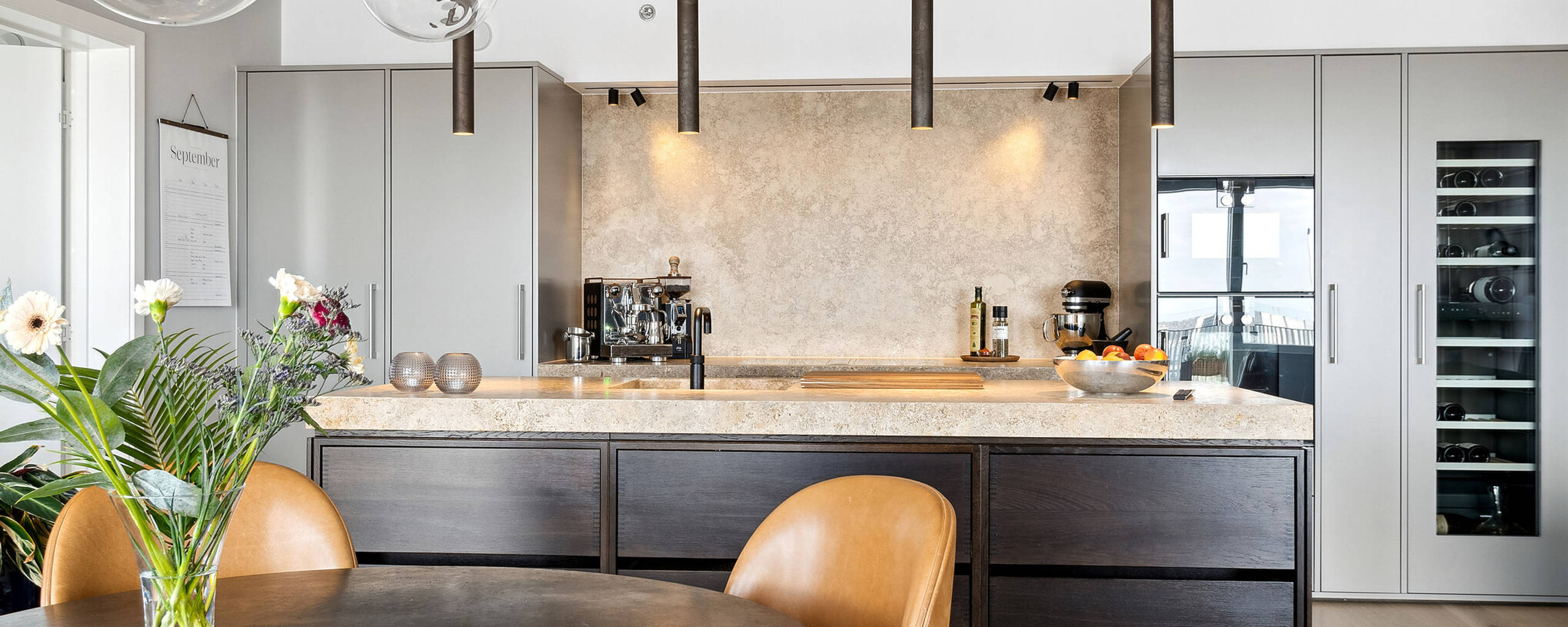 Grå Avantgarde högskåp skapar en minimalistisk bakgrund till köksön i rökt ek från uno form.