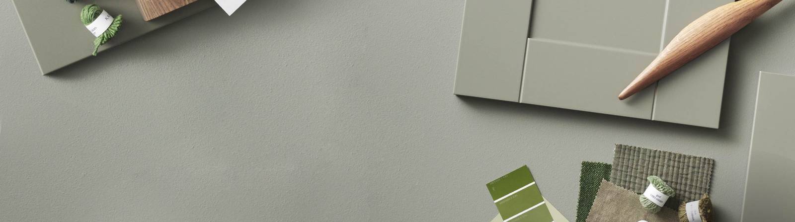 Grön kökslucka med färgprover och handtag i trä