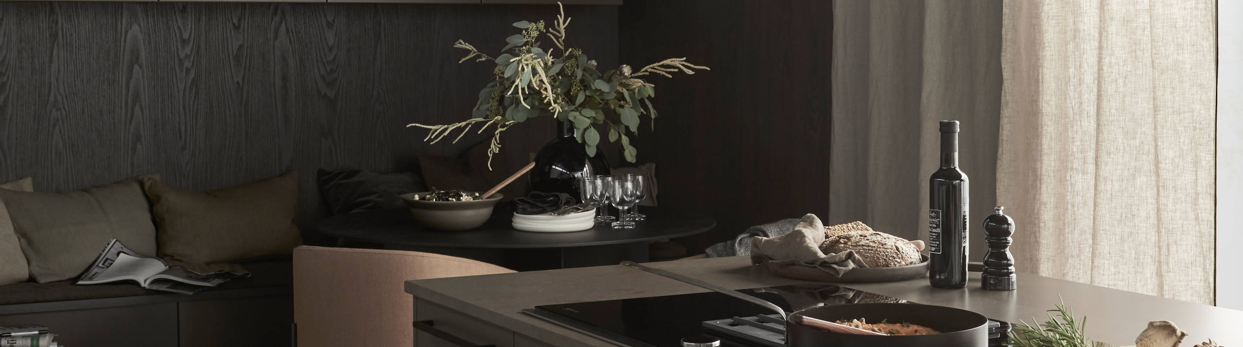 Lucka Arkitekt plus Bark målad i brun kulör. Köksö med bänkskiva Iron Bark i kvartskomposit. Matsalshörnet av väggskåp och sittbänk skapad av bänkskåp skapar inbjudande plats i köket.