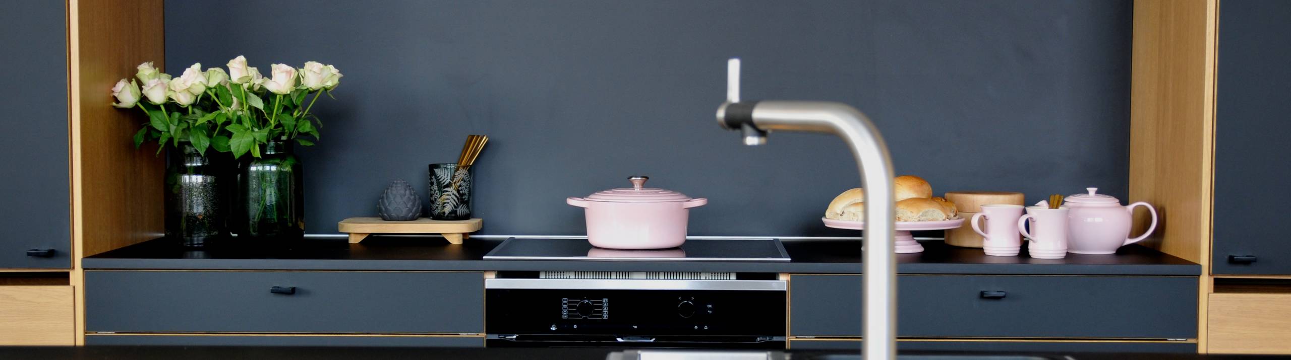 Modellen har slette fronter i sort supermatt høytrykkslaminat med fasede kantlister i heltre eik.